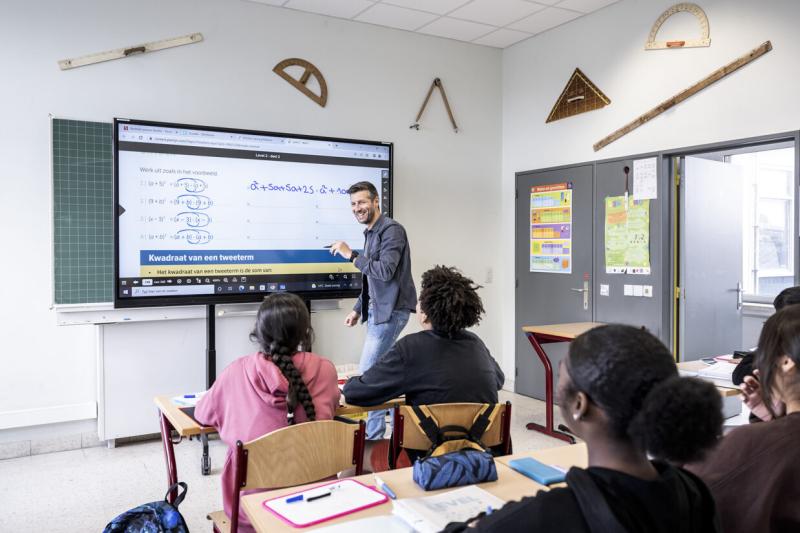 Een leerkracht van Panorama geeft les en toont oefeningen op het smartbord.